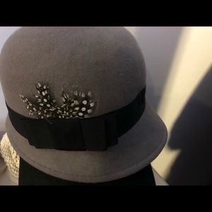 Gray bucket hat with black polka dot feather